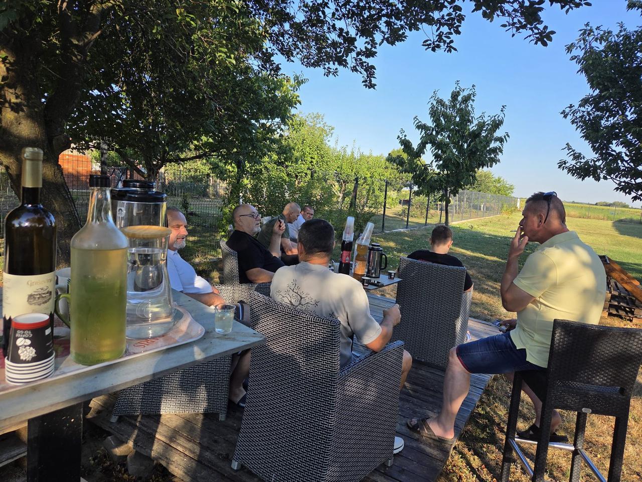 Spectators sitting outside with drinks and food awaiting pigeon arrivals at Derby AS Croatia loft