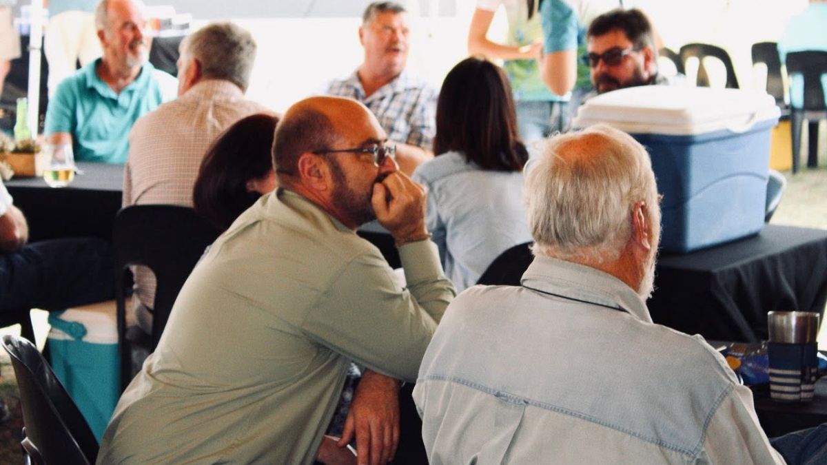 Pigeon fanciers and spectators gathered at tables following live race arrivals at the Marlbank OLR in South Africa