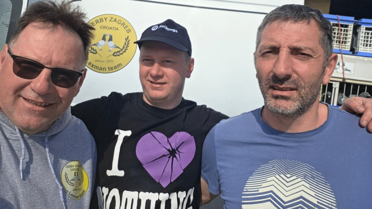 Three participants at Derby Zagreb during the 2026 semi final weekend, with the Derby Zagreb loft and logo in the background.