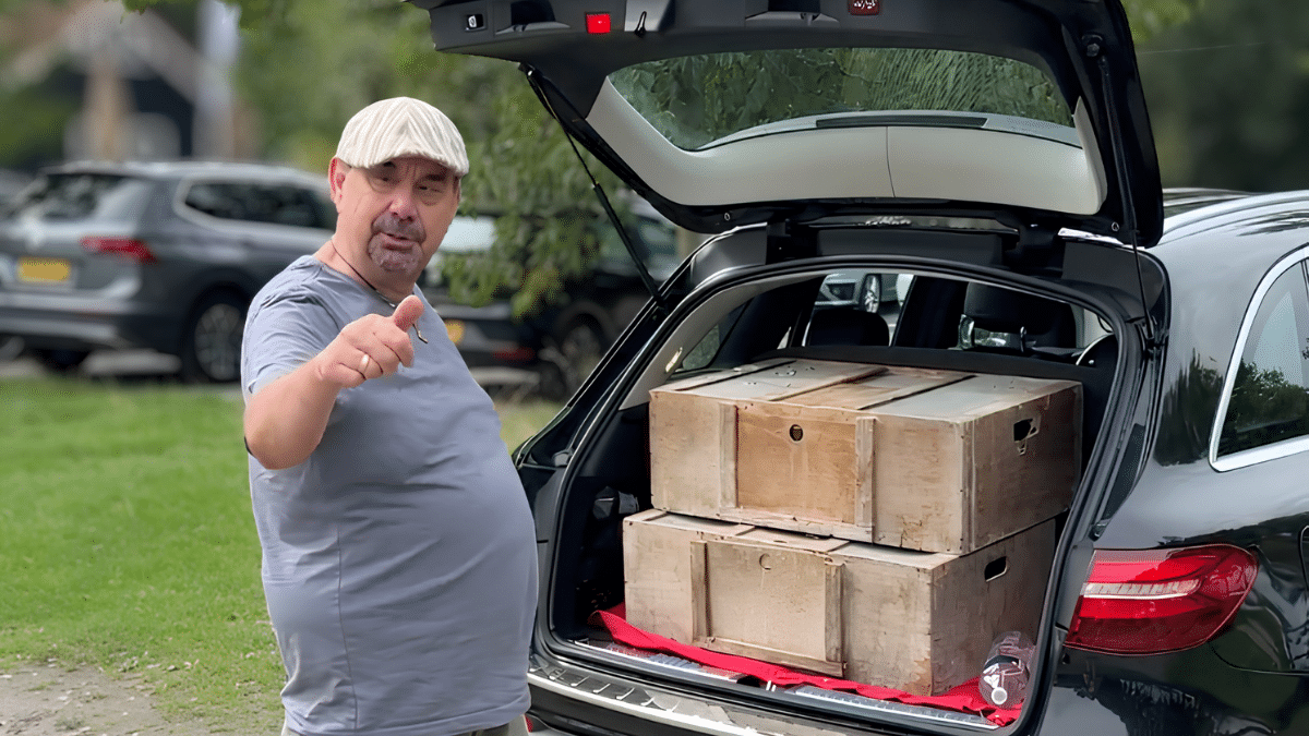 The Pigeon Boss beside an open car boot loaded with wooden pigeon crates for a 20 kilometre young pigeon training toss.