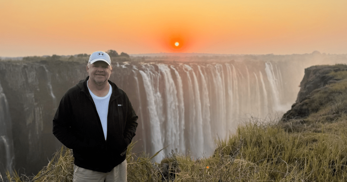 Daniel Hash from Avian Export Services, standing near a waterfall at sunset. Daniel is a well known man in the Pigeon Sport
