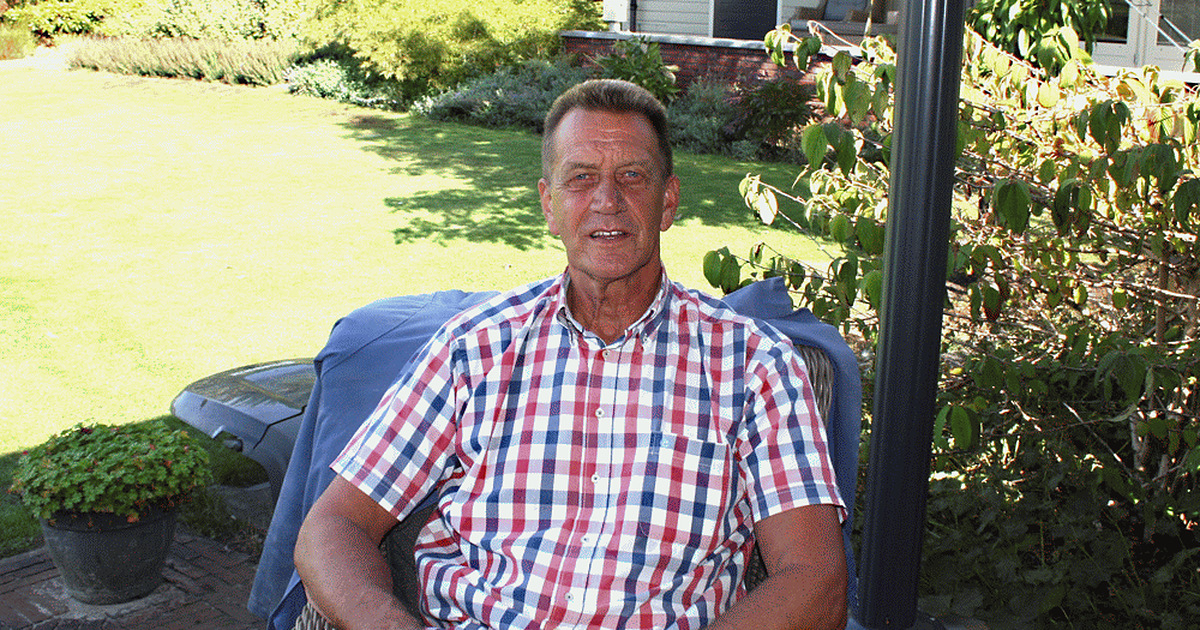 Home 6 Evert Diepeveen sitting outdoors in a garden chair in a checked shirt, with green plants and lawn behind him